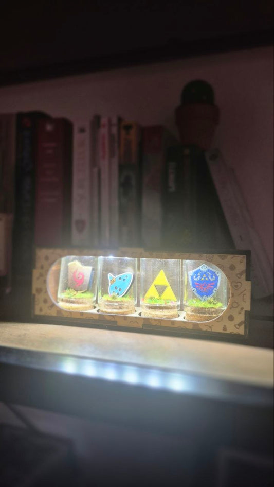 Détail des clochettes Triforce, Ocarina et boucliers dans le boitier lumineux Zelda